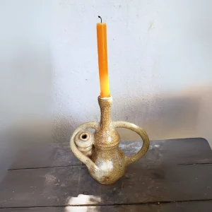 Candelabro trompo al costado de cerámica gres blanca hecho a mano, con vela naranja