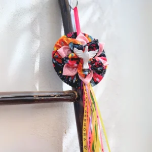 Disco Espíritu Santo artesanal con paloma blanca y cintas de colores colgado
