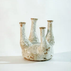 Candelabro o pieza central de cerámica blanca con múltiples brazos curvados hacia arriba, evocando la forma de una medusa.